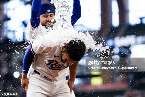 Marcus Semien receives a Powerade bath from Martin Perez of the Texas Rangers to celebrate a victory over the Chicago White Sox after a game at Globe...