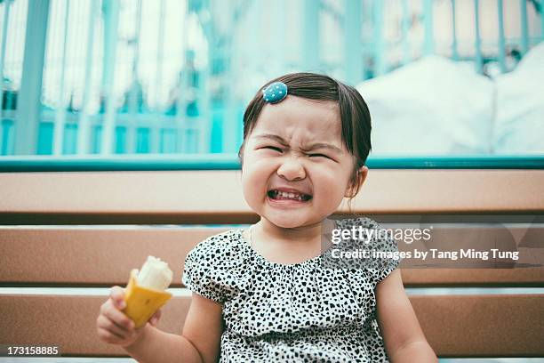 Toddler girl making funny face on a bench