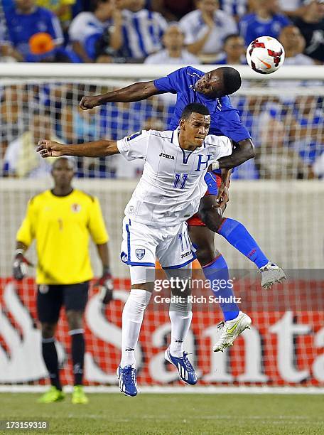 Defender Mechak Jerome of Haiti heads the ball away from midfielder Rony Martinez of Honduras during the first half of a 2013 CONCACAF Gold Cup...