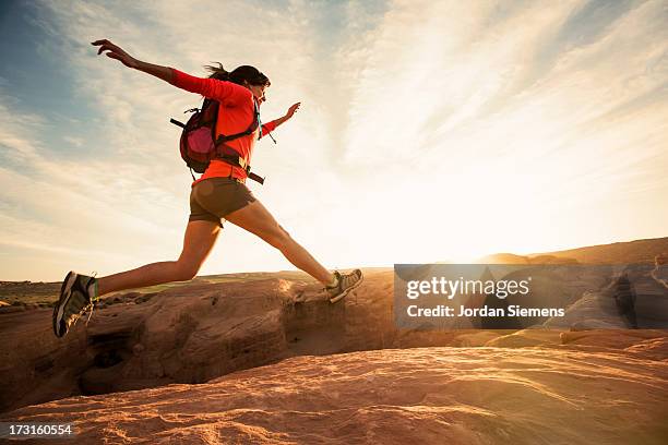 a female dayhiking in arches park. - extreme sports women stock pictures, royalty-free photos & images