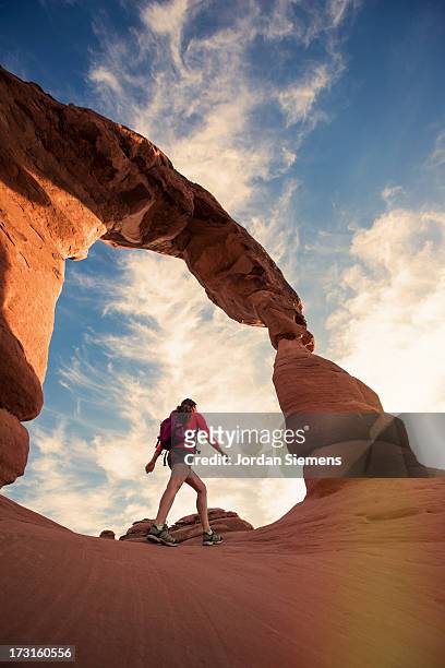 a female dayhiking in arches park. - delicate arch stock pictures, royalty-free photos & images