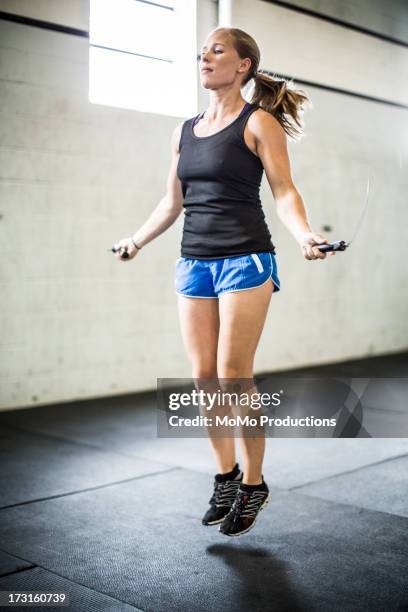 woman jumping rope - seilspringen stock-fotos und bilder