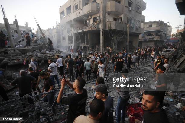 Palestinian people conduct a search and rescue operation after the Israeli airstrikes in Deir al-Balah, Gaza on October 18, 2023.