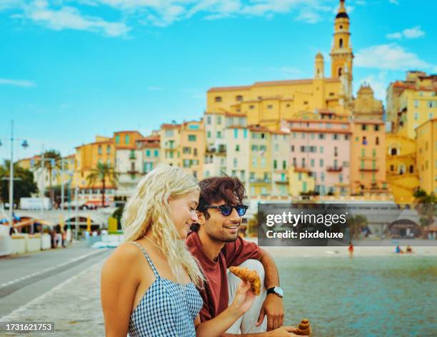 young millennial couple enjoying their trip to menton, while travelling in the south of france. - eating croissant stock pictures, royalty-free photos & images