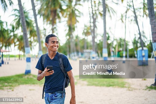 Male Hispanic tourist walking along Malecón Beach, Riohacha, Colombia