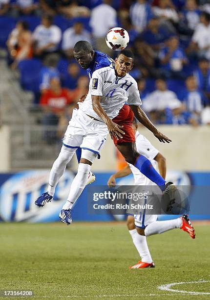 Midfielder Rony Martinez of Honduras heads the ball past midfielder Jean-Marc Alexandre of Haiti during the first half as in a 2013 CONCACAF Gold Cup...