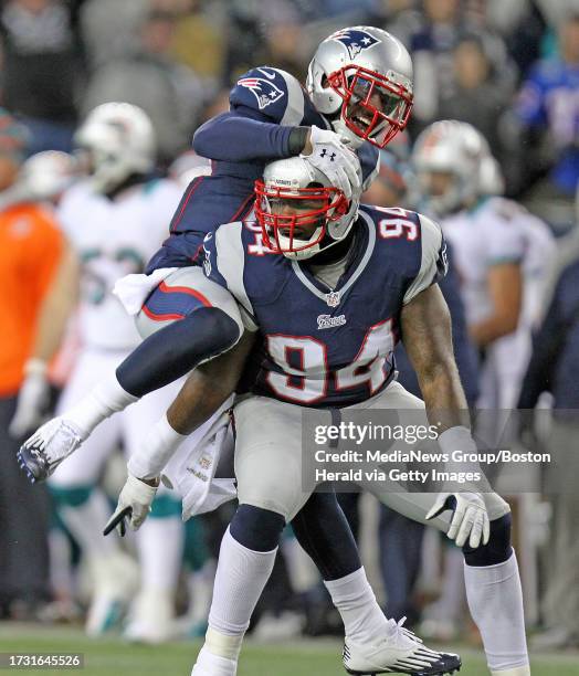 Foxboro - MA- - New England Patriots strong safety Tavon Wilson jumps on the back of defensive end Justin Francis in celebration of his sack on Miami...