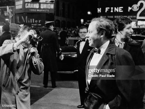 American playwright Tennessee Williams is filmed by a cameraman on his arrival at the premiere of 'Baby Doll' at the Victoria Theater, New York City,...