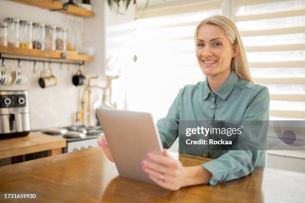 young woman with a digital tablet at home - 35 39 years stock pictures, royalty-free photos & images