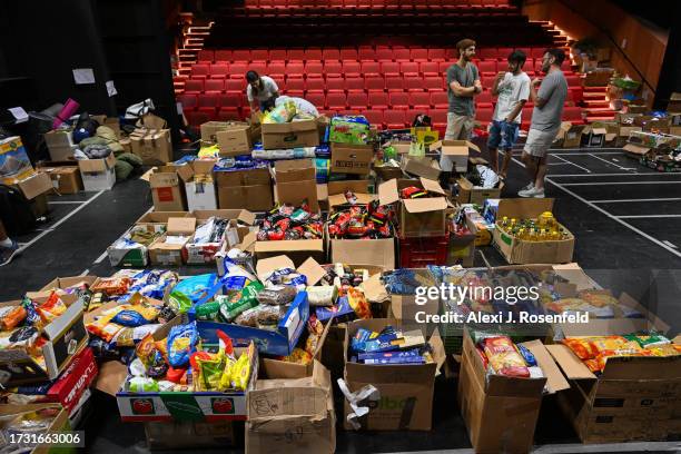 Volunteers pack boxes at an emergency situation room set up in a theatre by Lev Echad for soldiers and internally displaced people from the kibbutzim...