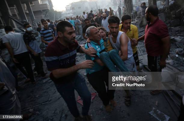 Image depicts graphic content) Palestinians evacuate an injured girl following an Israeli airstrike on Deir al-Balah, central Gaza Strip on October...