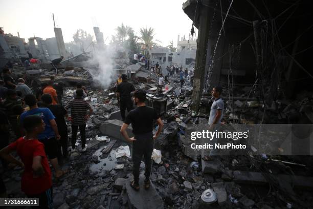 An overview of destroyed buildings as people gather to search for victims following an Israeli airstrike on Deir al-Balah, central Gaza Strip on...