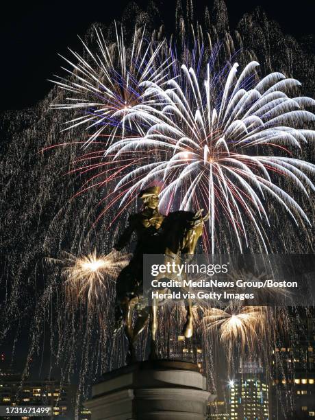 Fireworks explode over the George Washington Statue and the Boston Common and Public Gardens at the First Night celebration. Wednesday, December 31,...