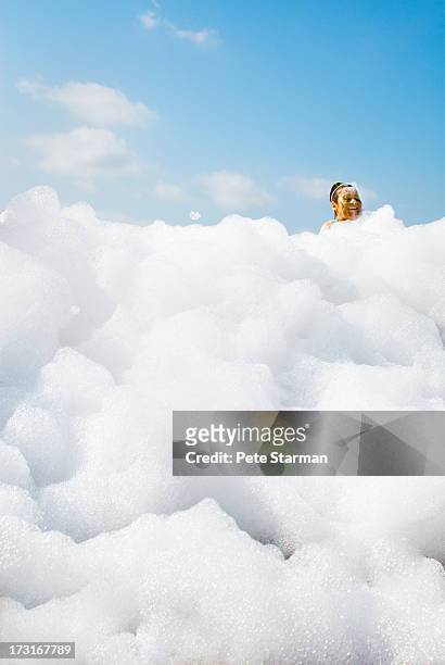 women in detergent foam at mud run. - soapbubble stock pictures, royalty-free photos & images
