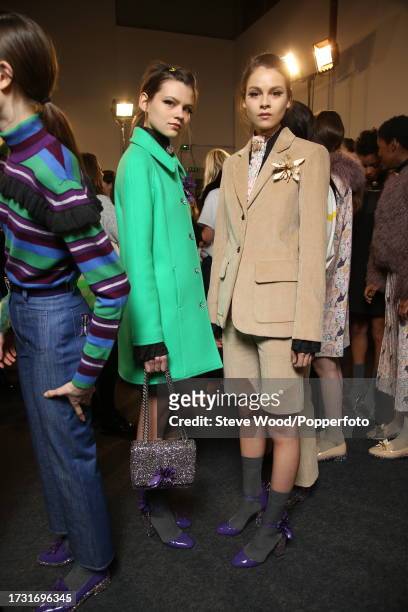 Backstage at the Paul & Joe show during Paris Fashion Week Autumn/Winter 2016/17, one model wears a fitted coat in emerald green wool, the other...