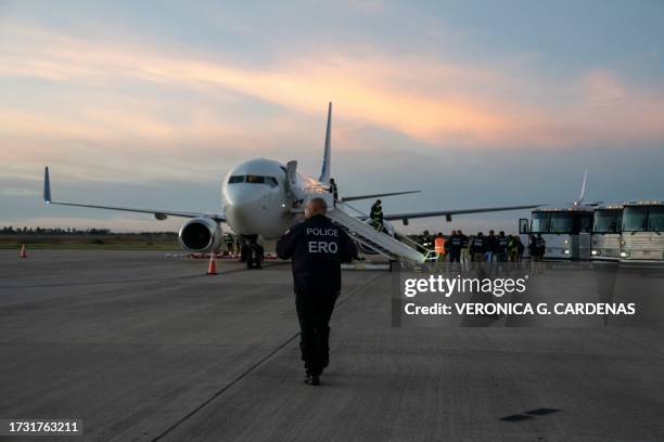 An Enforcement and Removal Operations police walks towards the first deportation flight of undocumented Venezuelans after a US-Venezuelan agreement...
