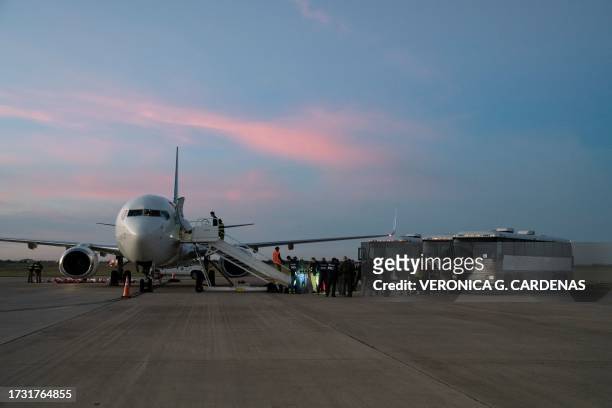 Migrants board a plane during the first deportation flight of undocumented Venezuelans from the United States to Venezuela, in Harlingen, Texas, on...