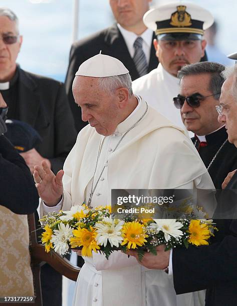 Pope Francis looks on moments before laying a wreath on July 8, 2013 in Lampedusa, Italy. On his first official trip outside Rome, Pope Francis...