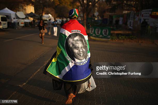 Street vendor sells souvenirs honouring former South African President Nelson Mandela at the memorial wall at the Medi-Clinic Heart Hospital on July...