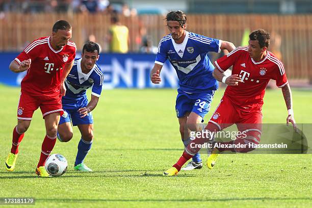 Franck Ribery of Bayern Muenchen and his team mate Mario Mandzukic battle for the ball with Ahmad Benali of Brescia and his team mate Massimo Paci...