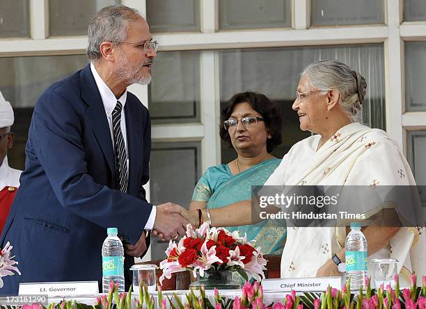 Newly appointed Lieutenant Governor of Delhi, Najeeb Jung, shake hand with Delhi Chief Minister Sheila Dikshit after taking oath at Raj Bhawan on...