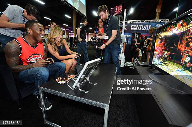 Lightweight Anthony Njokuani battles Octagon Girl Brittney Palmer in a videogame demo during day one of the UFC Fan Expo Las Vegas 2013 at the...