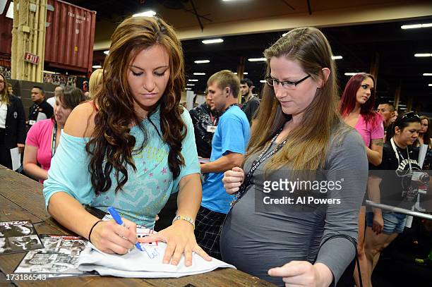 Women's bantamweight Miesha Tate signs autographs for fans during day one of the UFC Fan Expo Las Vegas 2013 at the Mandalay Bay Convention Center on...