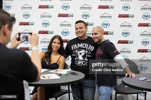 Octagon Girl Arianny Celeste and host Jon Anik pose for a photo with a fan during day one of the UFC Fan Expo Las Vegas 2013 at the Mandalay Bay...