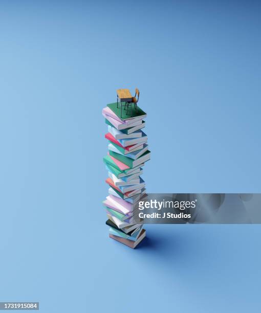 oversized stack of books with school table on top - bulk test stock-fotos und bilder