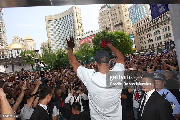 Dwyane Wade waves to a large crowd in front of Li-Ning Flagship store during store visit on July 8, 2013 in Shanghai, China.