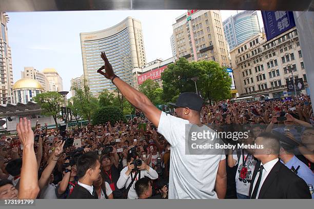 Dwyane Wade waves to a large crowd in front of Li-Ning Flagship store during store visit on July 8, 2013 in Shanghai, China.