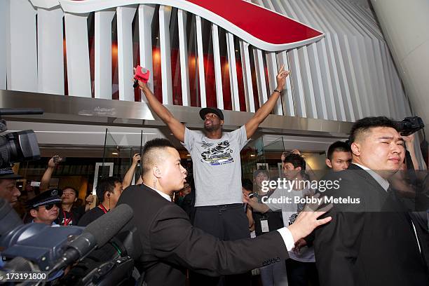 Dwyane Wade waves to a large crowd in front of Li-Ning Flagship store during store visit on July 8, 2013 in Shanghai, China.