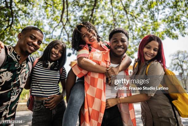 porträt einer universität, die sich im freien umarmt - dominikanischer abstammung stock-fotos und bilder