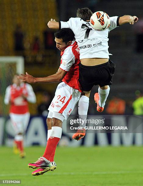 Colombia's Independiente Santa Fe player Hugo Acosta vies for the ball with Enzo Prono of Paraguay's Olimpia during their 2013 Copa Libertadores...