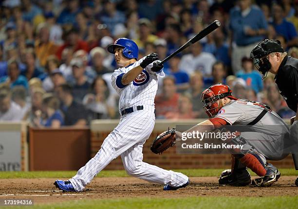 Darwin Barney of the Chicago Cubs follows through on a three-run home run scoring Dioner Navarro and Nate Schierholtz during the sixth inning as...
