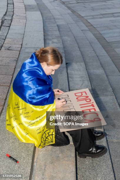 Student writes inscriptions "Fight - Win" on a placard. On Independence Square in the Ukrainian capital, more than 50 students recreated the events...