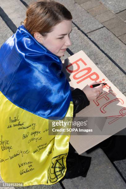 Student writes inscriptions "Fight - Win" on a placard. On Independence Square in the Ukrainian capital, more than 50 students recreated the events...