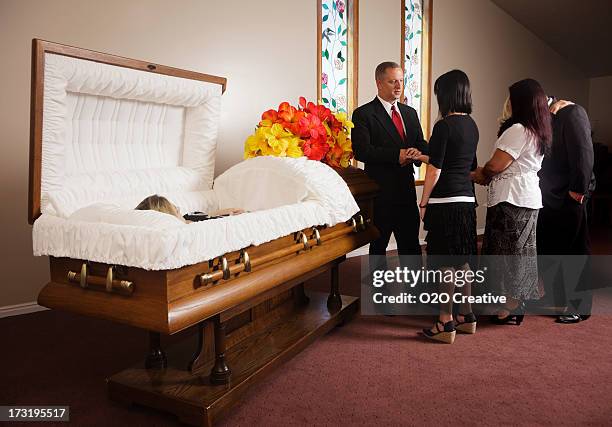 family receiving guests at a funeral - funeral casket stock pictures, royalty-free photos & images