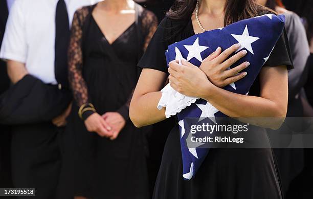 woman holding flag at a funeral - 寡婦 個照片及圖片檔