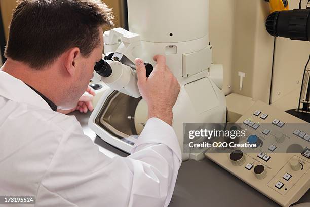 scientist using an electron microscope - electron microscope stock pictures, royalty-free photos & images