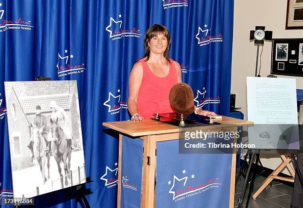 Jean S. Beekman, president of In Person Inc., gifts Princess Diana's riding helmet to Diana's first grandchild at In Person Inc. On July 9, 2013 in...