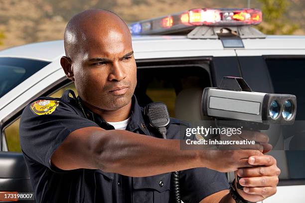 police officer checking vehicle speed with radar gun - lasergun stockfoto's en -beelden