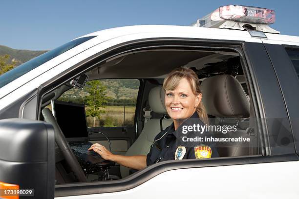 feliz mujer policía en automóvil coche de policía en ordenador - border patrol fotografías e imágenes de stock