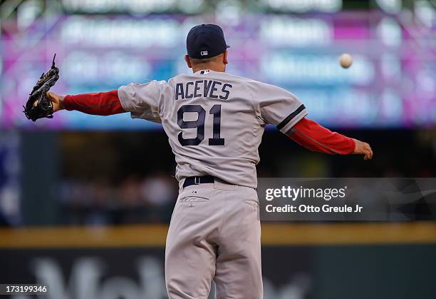 Relief pitcher Alfredo Aceves of the Boston Red Sox attempts to catch a line drive by Dustin Ackley of the Seattle Mariners in the third inning at...