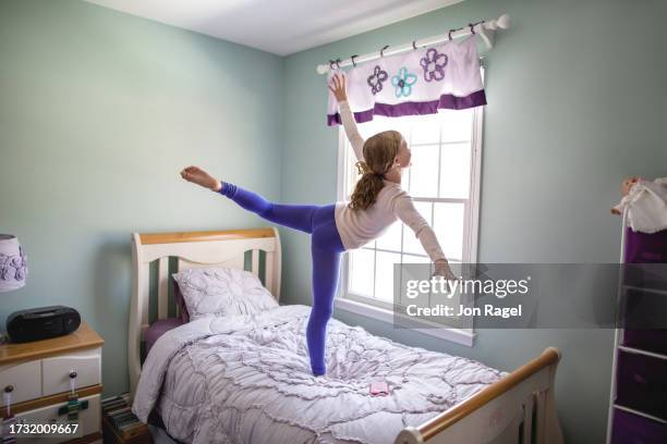 little ballerina in arabesque on bed - ballet arabesque stock pictures, royalty-free photos & images