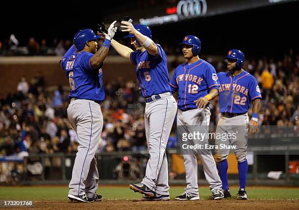 David Wright, Juan Lagares, and Eric Young Jr. #22 congratulate Marlon Byrd of the New York Mets after Byrd hit a grand slam home run that scored...