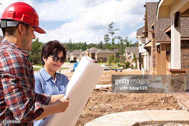 builder meeting with woman at new home construction - new cultures stock pictures, royalty-free photos & images