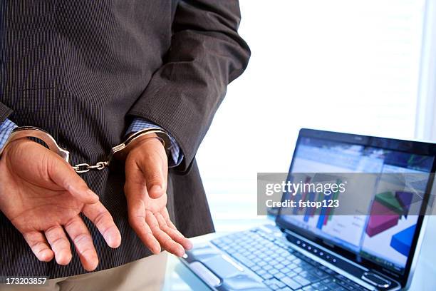 white collar crime. businessman in handcuffs. - hiding behind laptop stock pictures, royalty-free photos & images