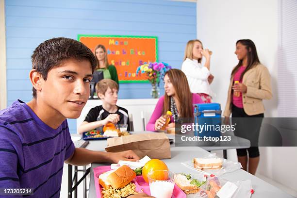teens in school cafeteria eating lunch. menu on wall - cafeteria menu stock pictures, royalty-free photos & images