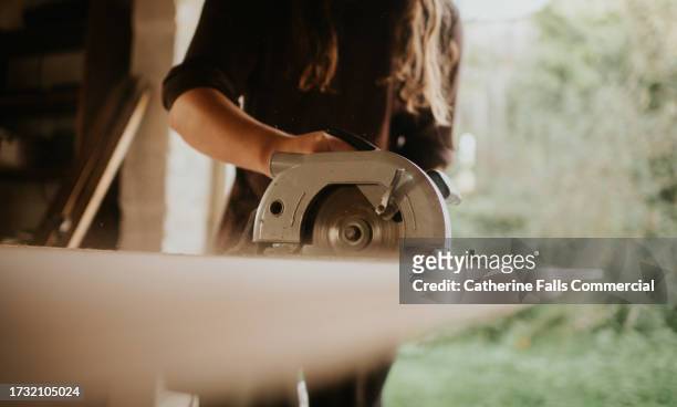 a person cuts timber with an electric power tool - hand tool stock pictures, royalty-free photos & images